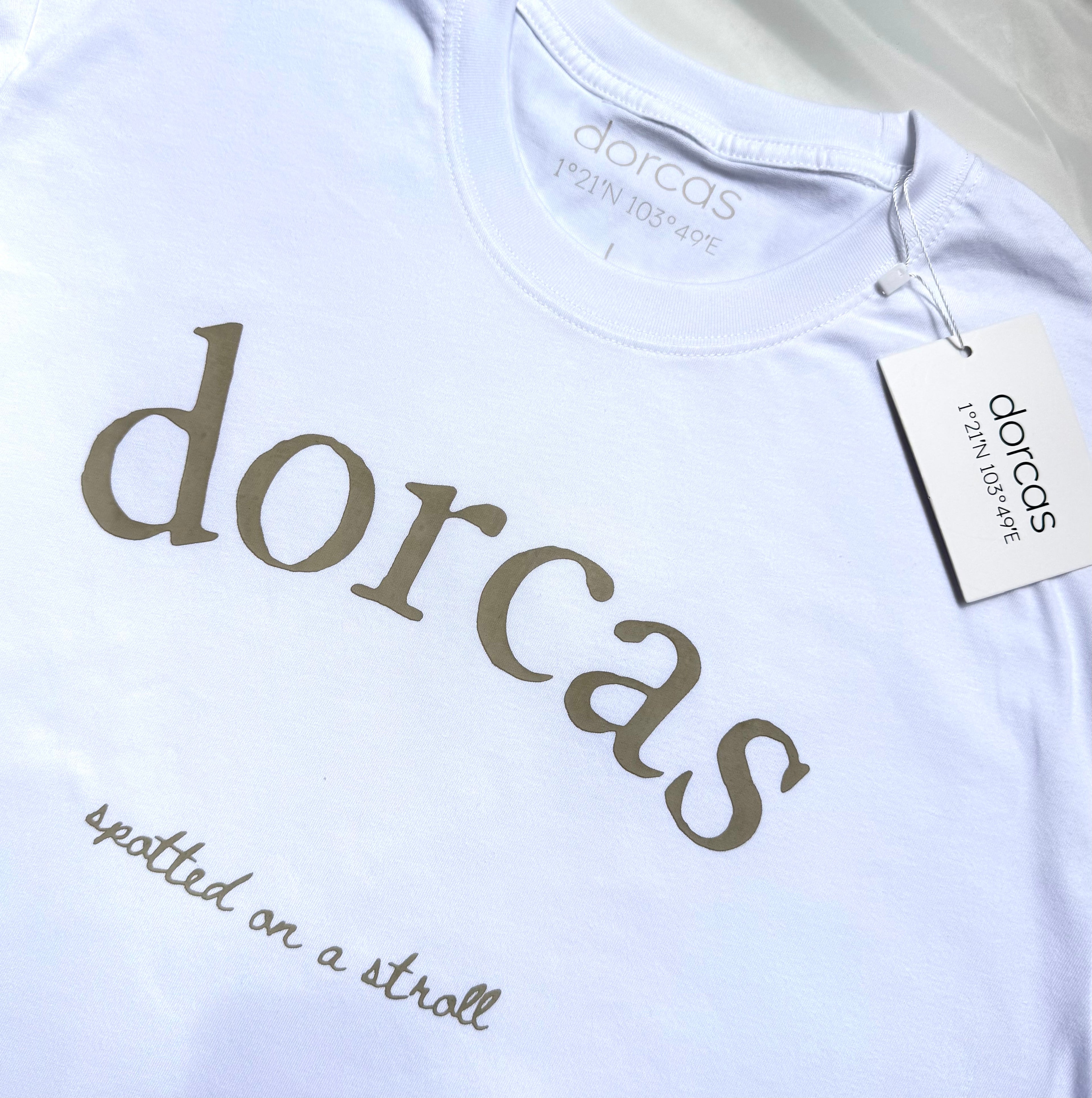 White t-shirt with 'dorcas' branding and text on a white background